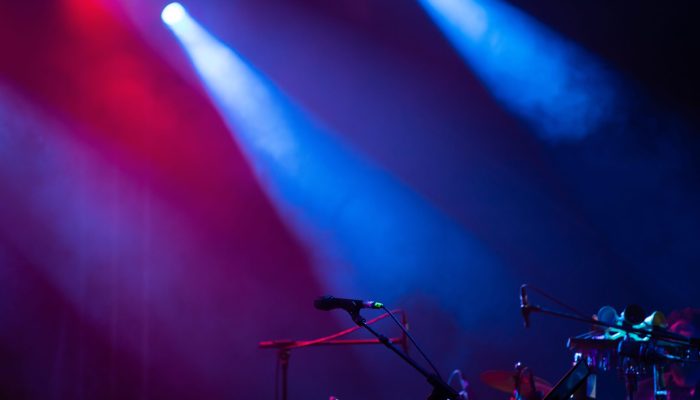 Microphone in colored spotlights and smoke. Concert and theatre scene